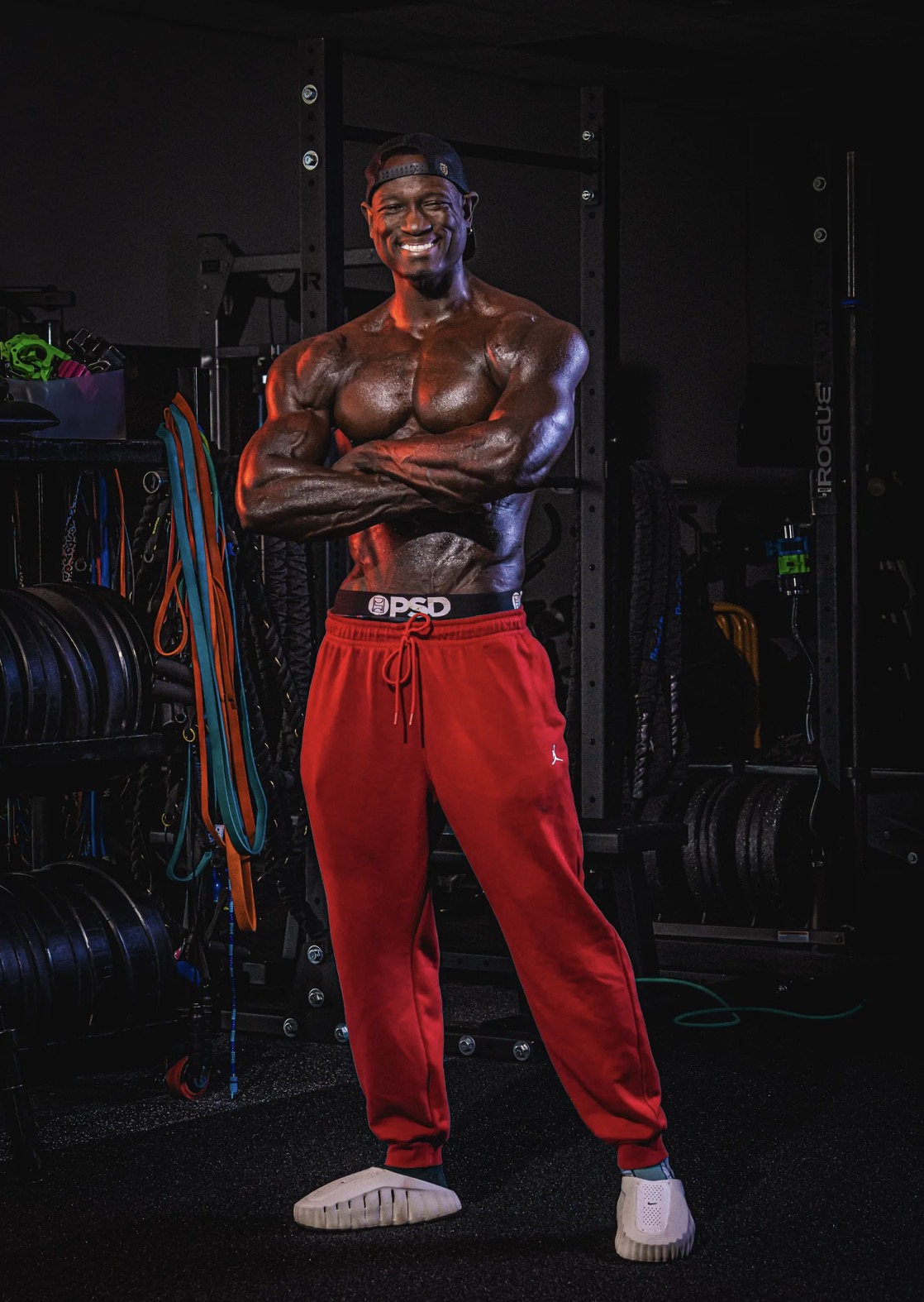 Coach JR standing with arms crossed in the gym